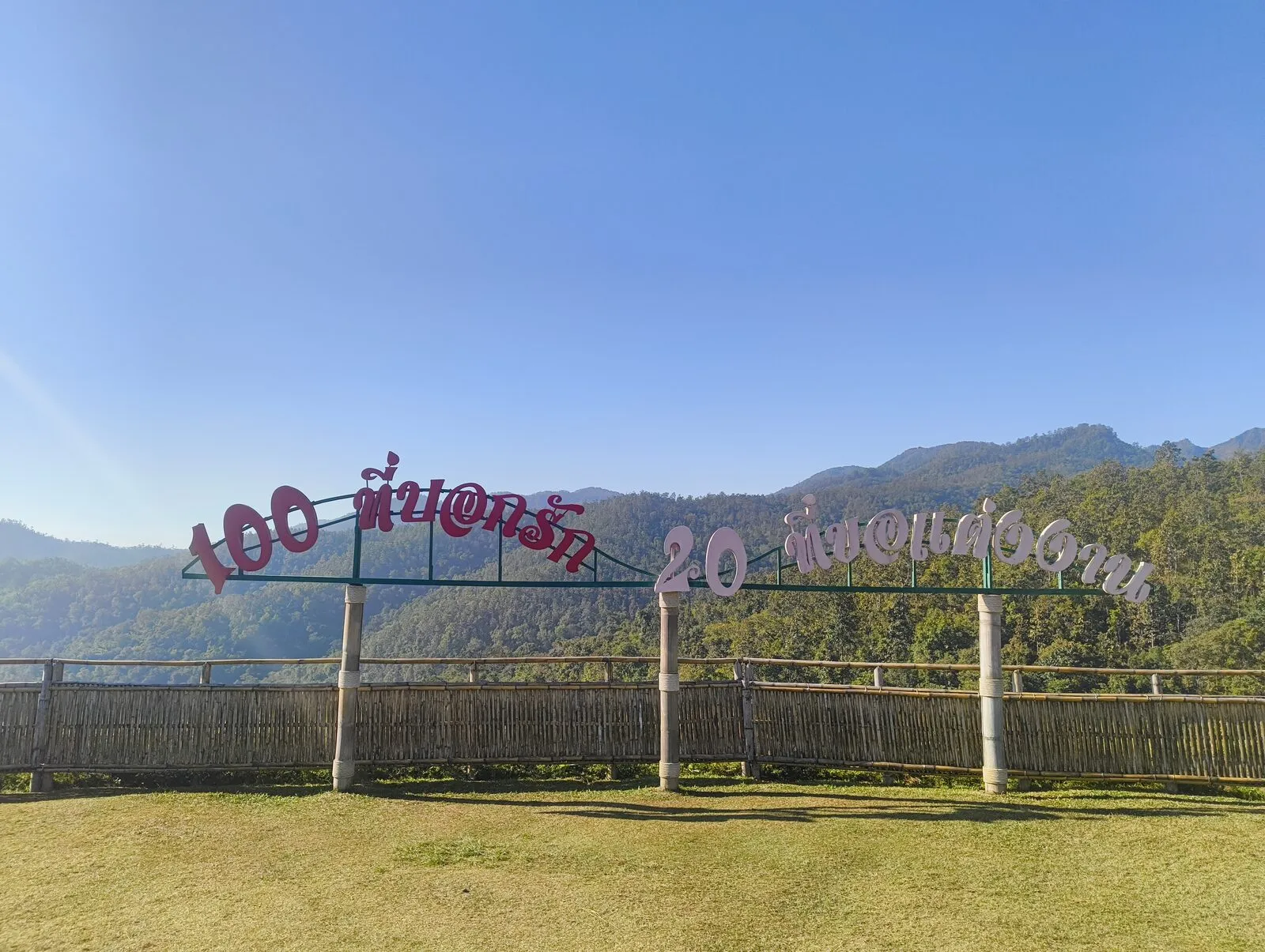 A hilltop sign reading 100 years above a mountain valley