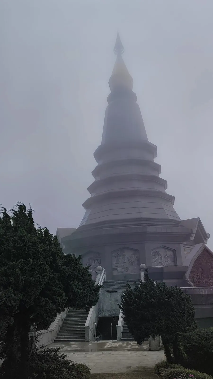 A tiered royal pagoda rising into thick fog