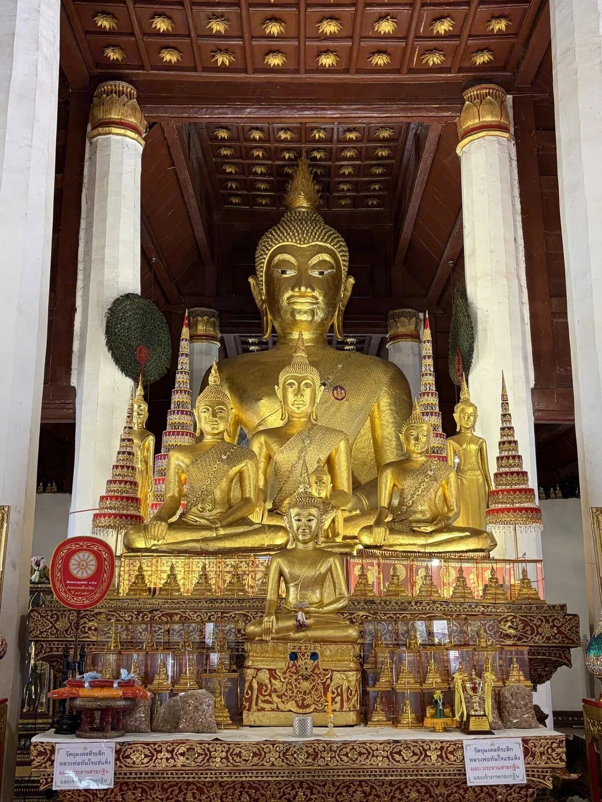A large golden Buddha statue inside a richly decorated temple