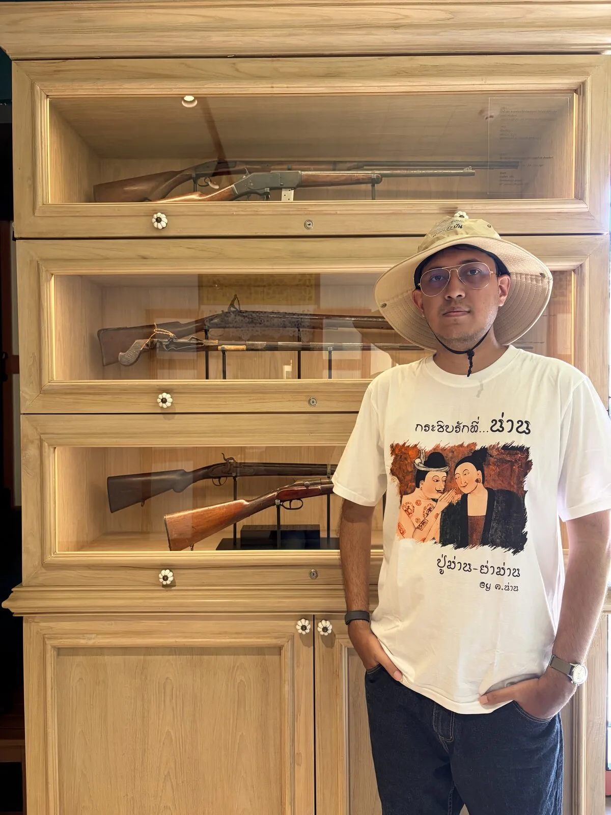 A visitor standing beside a museum display case