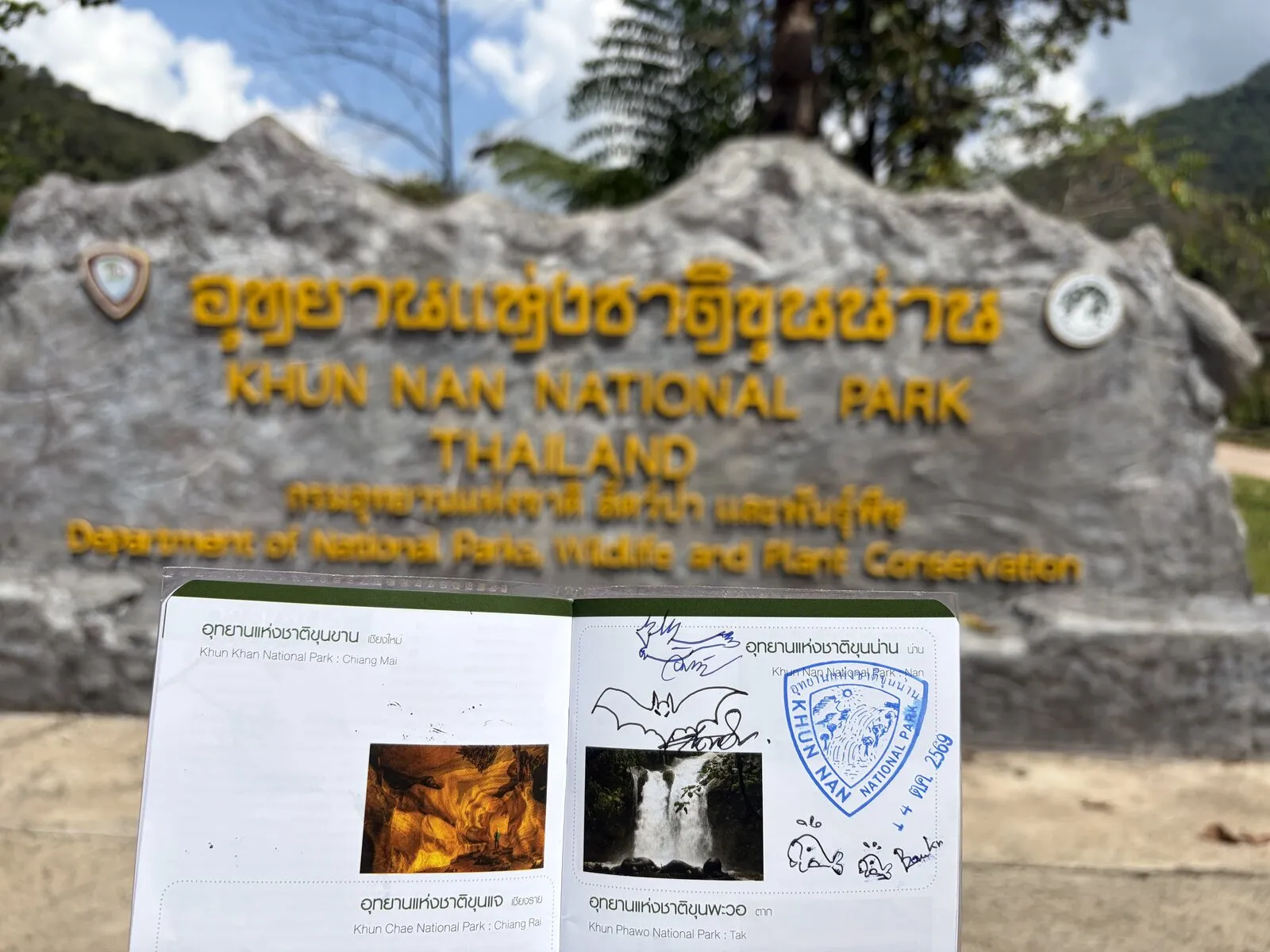 A park sign with a notebook of stamps and handwritten notes