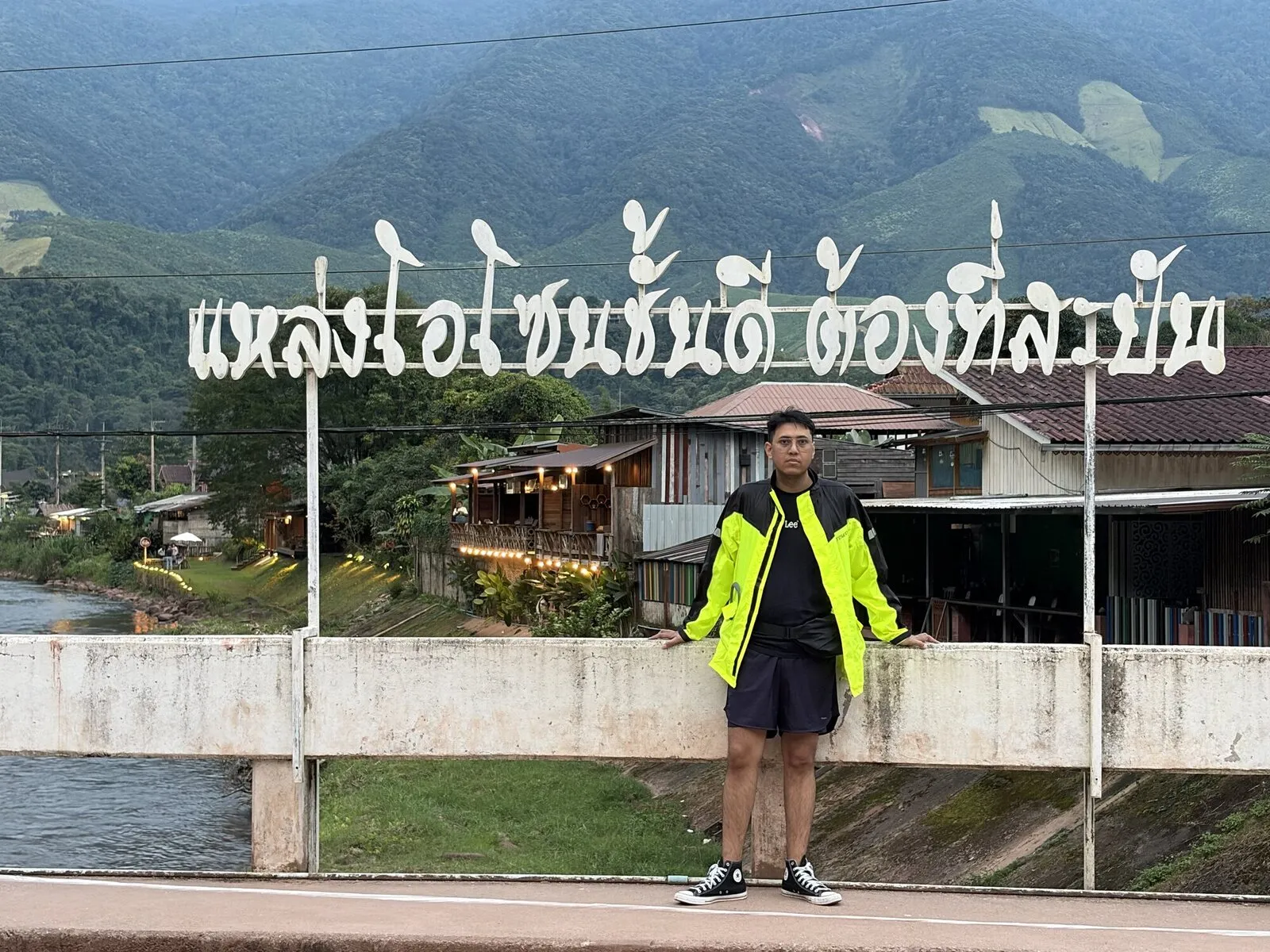 A rider standing on a concrete bridge beneath a large sign