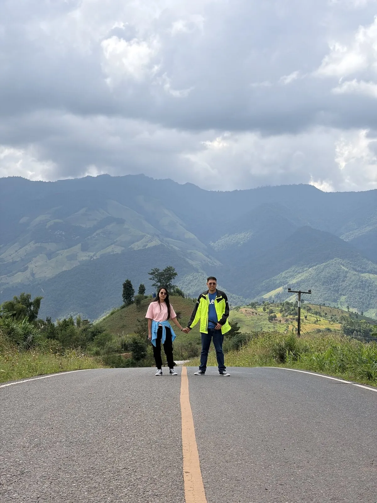 Two people standing on a ridge road beside their motorcycles
