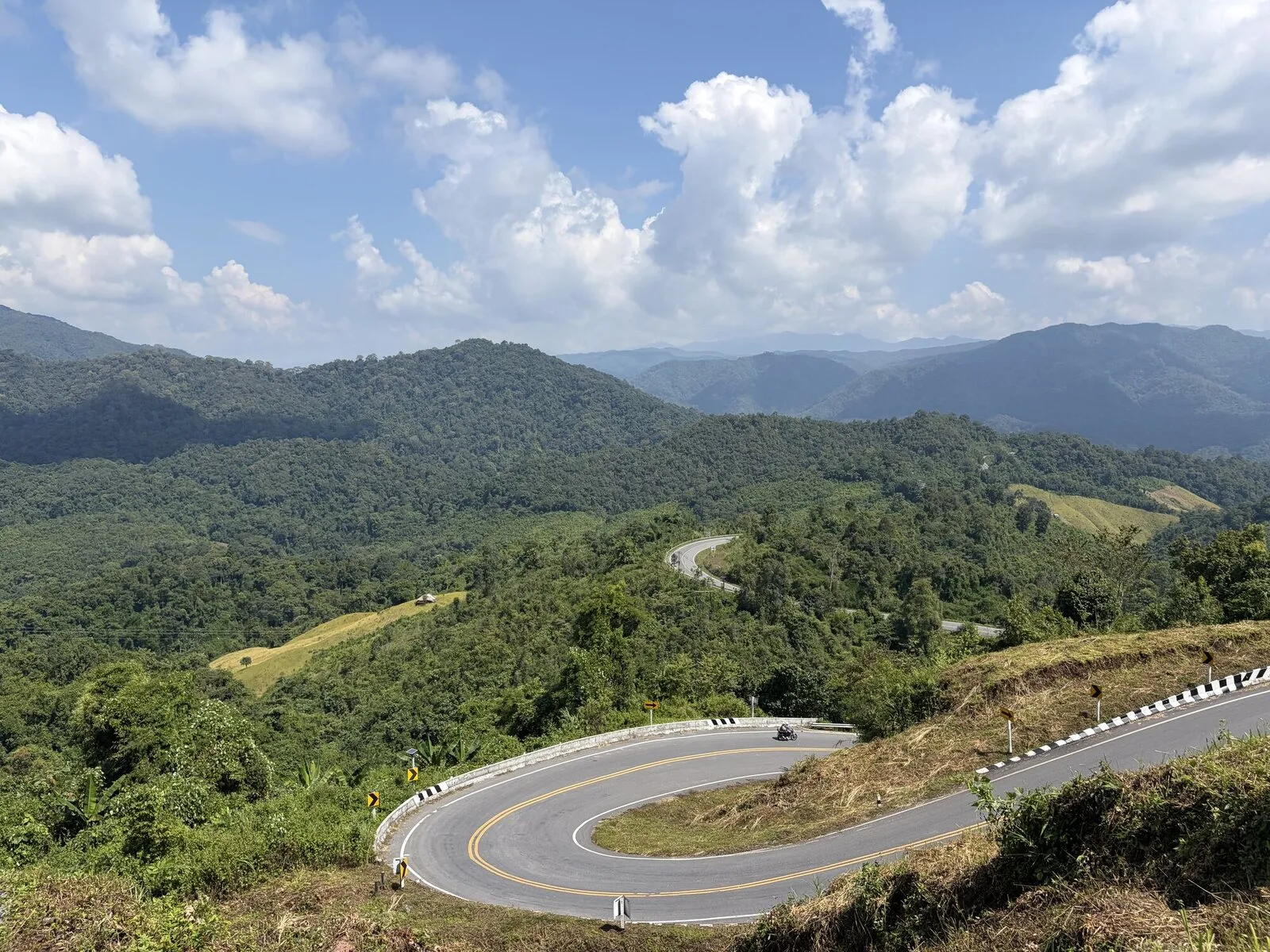 A narrow road winding along a green mountain valley
