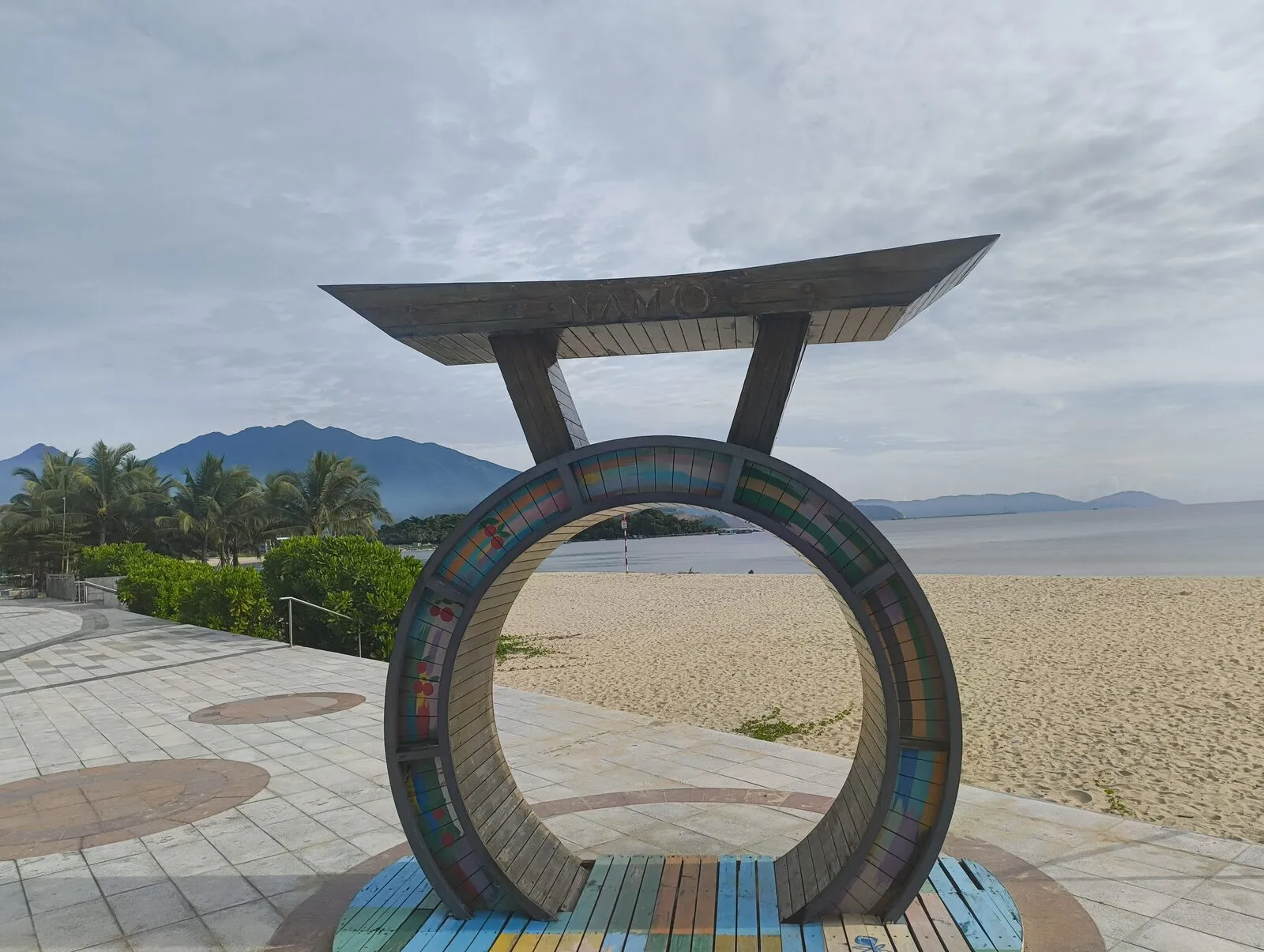 A circular sculpture spelling Da Nang on a wide beach